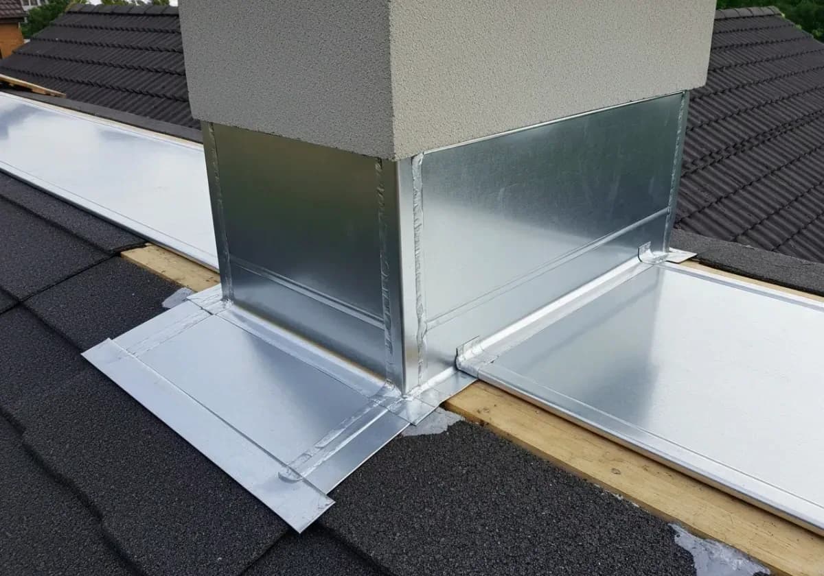 After — chimney flashing repair: Rusted, weeping flashing swapped for fresh metal, sealed where chimney meets roofline.