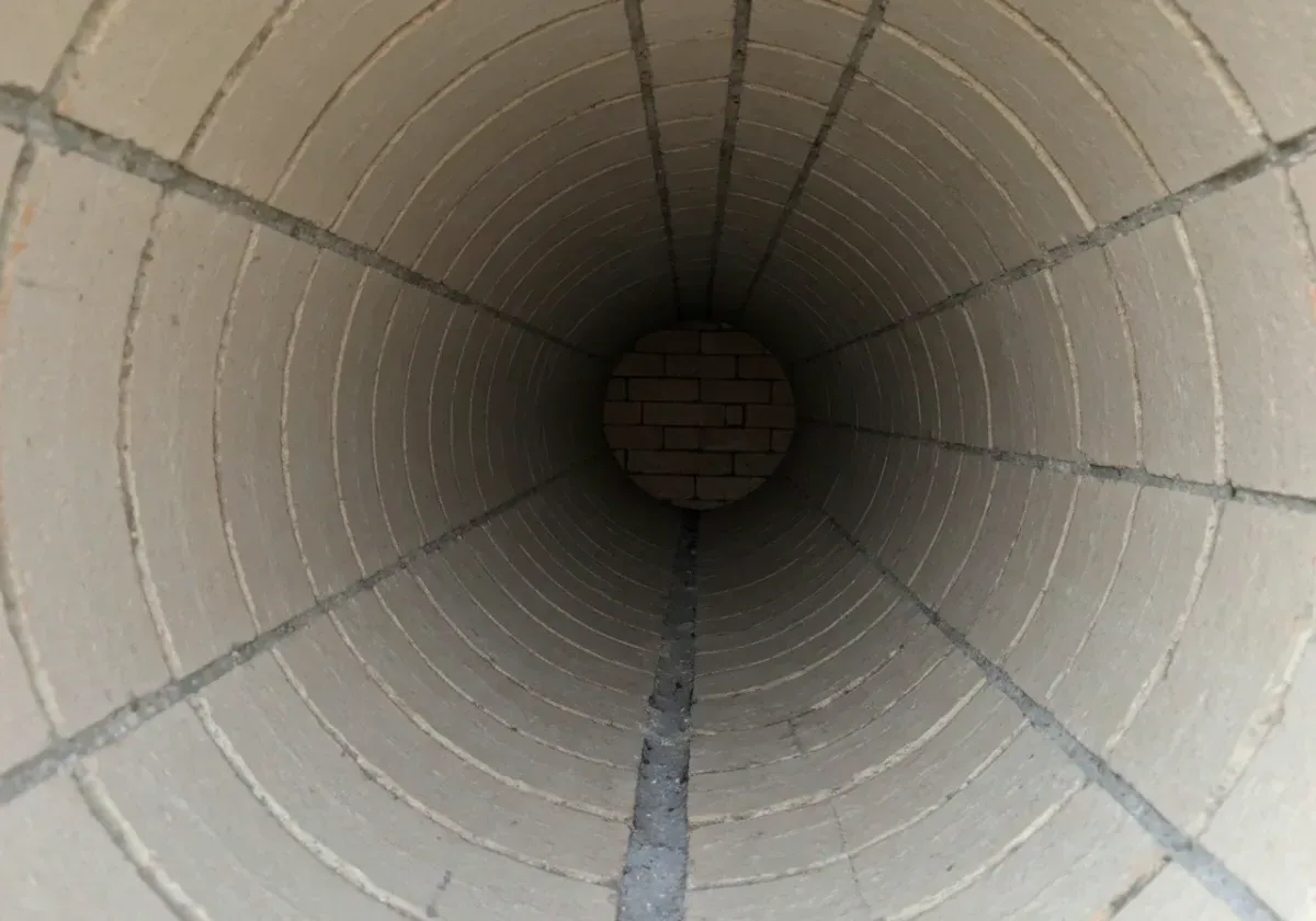 After — creosote removal: Hard, glazed creosote stripped from the flue walls — fire fuel gone, clean masonry back.
